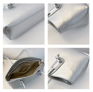 Detail of silver metallic tote bag showing knotted handles and pleated texture details