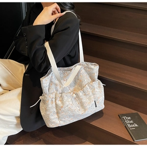 Detail of floral tote bag with lace mesh overlay and orange print on stairs