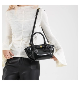 Detailed view of black oil wax leather bucket bag with pleated design and gold metal buckle