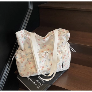 Detailed shot of floral canvas tote bag showing side drawstrings and high-quality fabric texture