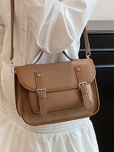 Brown lychee leather messenger bag with flap closure and double decorative straps