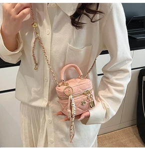 Détail d'un mini sac boîte matelassé rose avec bandoulière chaîne, cadenas et foulard en soie