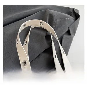 Vue macro détaillée de la poignée du sac blanc cassé avec des œillets métalliques argentés