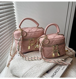 Détail d'un sac boîte matelassé rose avec chaîne dorée et fermetures à fleurs