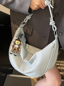 Light blue half-moon tote bag in textured leather with a unique knotted shoulder strap