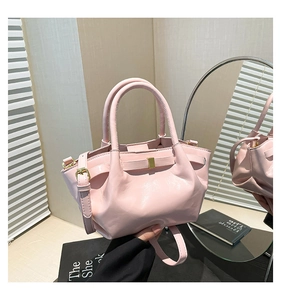 Close-up of pink pleated bucket bag with oil wax finish and elegant gold buckles