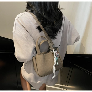 Brown lychee leather bucket bag detail with fashion engraving and cute bear charm