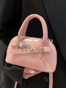 Pink patent leather shell bag with top handle and silver buckle details for women