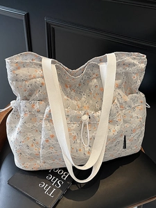 Floral lace tote bag with pleats and orange flower pattern shown on a chair