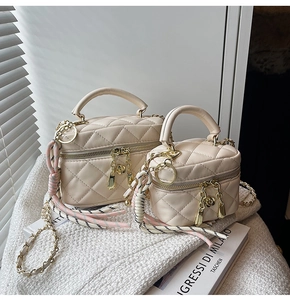 Détail du mini sac matelassé beige et du sac boîte avec fermeture éclair fleurie dorée
