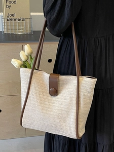 Minimalist straw tote bag with brown leather trim and shoulder strap for women