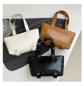 Trois sacs cabas minimalistes en blanc, marron et noir avec détails d'oeillets métalliques