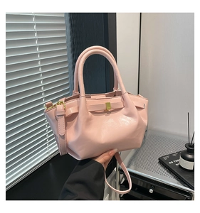 Detail view of pink oil wax leather bucket bag with bow ornament and gold hardware