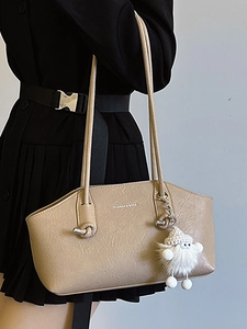 Minimalist light brown leather shoulder bag with plush pendant and metal logo detail