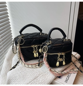 Détail du sac boîte matelassé noir avec double fermeture éclair dorée et sangle