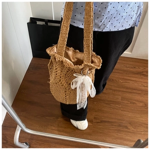 Detailansicht der gewebten Beuteltasche mit eleganter Spitzenschleife und Wellenrand