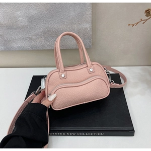 Detail of pink lychee grain leather handbag with silver hardware and wave zipper pocket