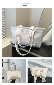 Détail du grand sac cabas blanc en cuir ciré avec œillets argentés et logo embossé mode
