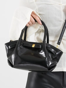 Glossy black oil wax leather bucket bag with bow detail and gold hardware for women