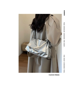 Détail du sac argenté en similicuir froissé avec bandoulière chaîne porté par un mannequin