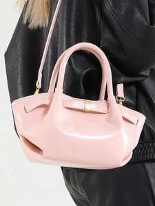 Pink waxed leather bucket bag with top handles and adjustable strap worn cross-body
