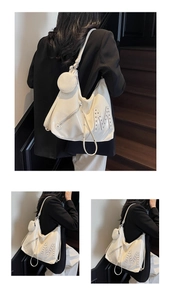 Detailed view of cream hobo bag featuring silver rivet M letter and round coin purse