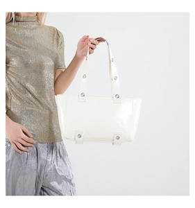Détail d'un grand sac cabas blanc en cuir ciré avec œillets métalliques pour le bureau
