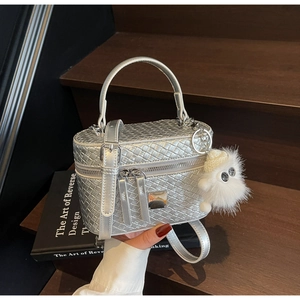 Detail view of silver woven texture box bag with metallic finish and furry charm