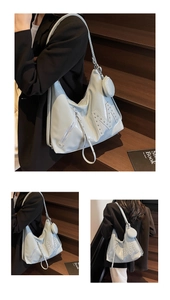 Detail of light blue soft leather tote with rivet M letter and small round coin purse