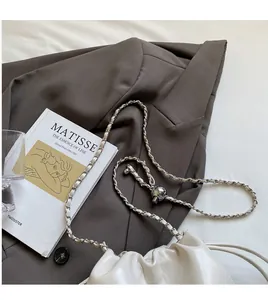 Detail of white cloud bag featuring soft leather pleats and adjustable metal ball chain strap