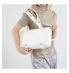 Détail du sac cabas en cuir ciré crème avec large bandoulière à œillets sur mannequin