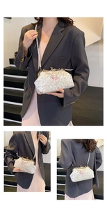 Detailansicht der Perlen-Schmetterlingsstickerei auf einer weißen Satin-Abendtasche mit Kette