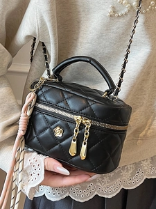 Petit sac matelassé noir avec fleur de camélia et bandoulière en chaîne dorée