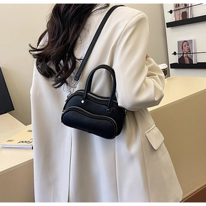 Litchi pattern black leather bowling bag shown on a model for scale and style