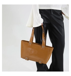 Vue détaillée du sac cabas marron caramel avec œillets métalliques sur les bretelles