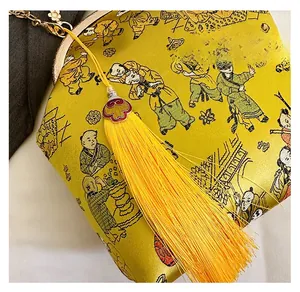 Vue détaillée du sac en soie jaune brodée avec des glands chinois traditionnels