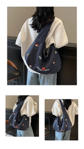 Dettaglio della borsa denim blu scuro con ricami colorati e scritta Good Vibes