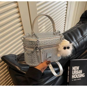 Detail of silver woven texture box bag with plush monster charm and metal chain