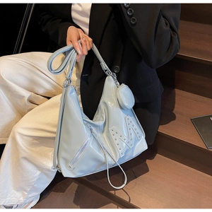 Detail of light blue glossy faux leather tote bag with rivet M logo and mini pouch