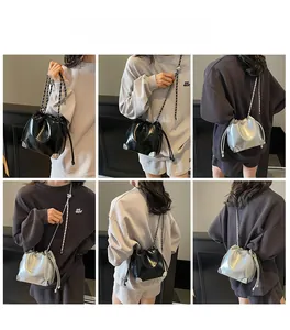 Detail of drawstring bucket bag showing metal corner protectors and chain shoulder strap