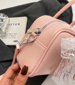 Close-up of pink pillow bag with silver metal zipper and white lace decorative edging
