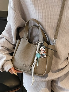 Chic taupe lychee leather bucket bag with metallic zipper and cute cartoon pendants