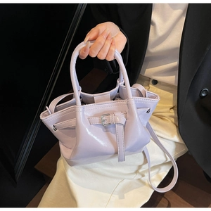 Detail der fliederfarbenen Lackleder-Eimertasche mit Tragegriff und Schultergurt