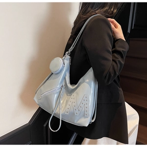 Light blue patent leather tote with rivet M detail and matching mini pouch on model