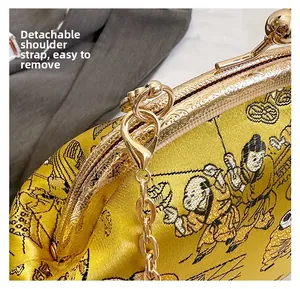 Détail de la bandoulière chaîne dorée et broderie sur le sac à main en soie jaune