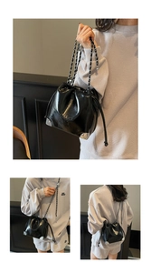Detail view of black drawstring bucket bag with silver metal corners and chain strap