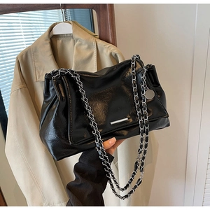 Détail du sac cabas noir brillant avec double chaîne argentée et finition métallique