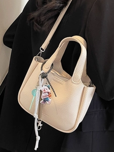 Minimalist beige lychee texture bucket bag with top handle and crossbody strap