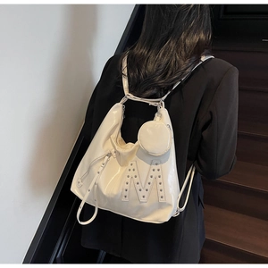 Close-up of white glossy tote with silver rivet M logo and detachable round coin purse