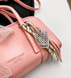 Detail of pink leather bag with lace trim, colorful lanyards and tennis racket charms